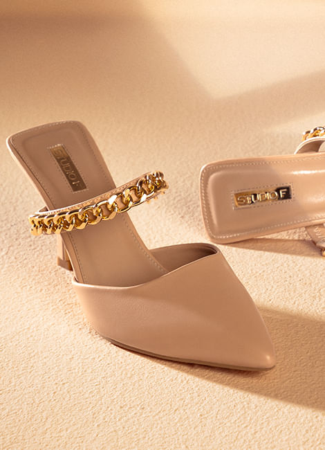 Imagen de un par de zapatos cerrados de tacón en color nude con tira dorada en el empeine